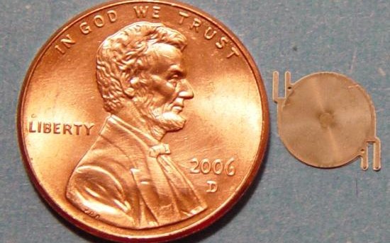 A microfabricated metal gas chromatography column next to a penny